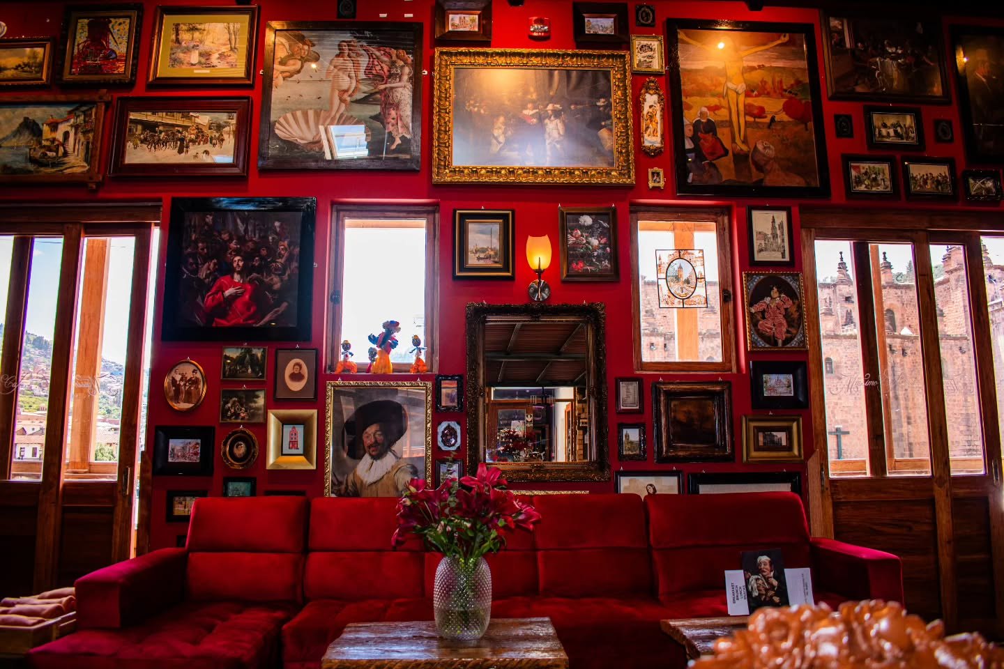 Lounge de Mássimo Café terminado, con muro de cuadros y sofá de terciopelo