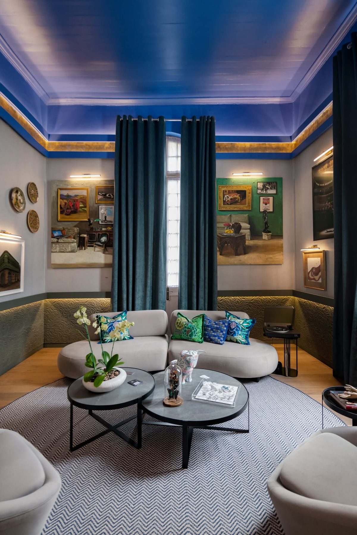 Sala residencial con techo azul profundo y arte de gran formato