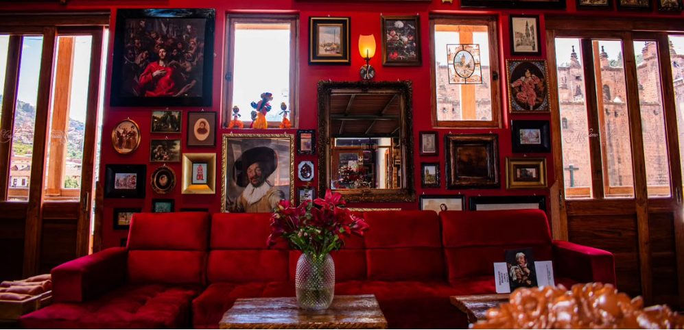 Muro rojo de cuadros y sofá de terciopelo en Mássimo Café